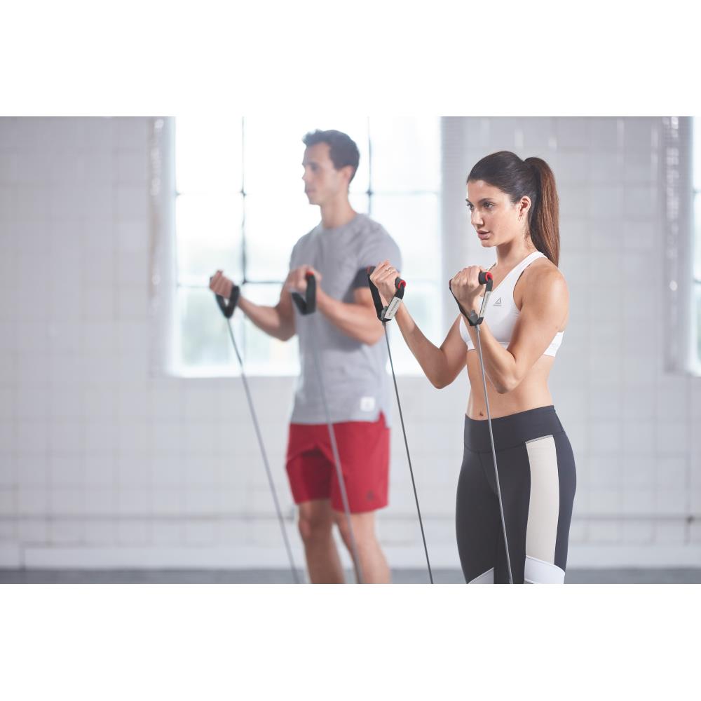 Woman doing resistance training with a Reebok Resistance Tube - Light