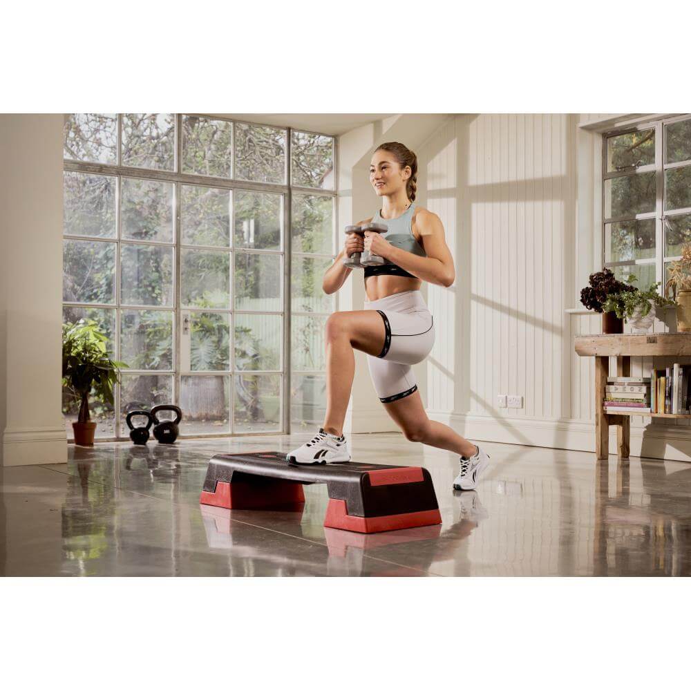 Woman performing a Reebok Step Home HIIT Workout - Red