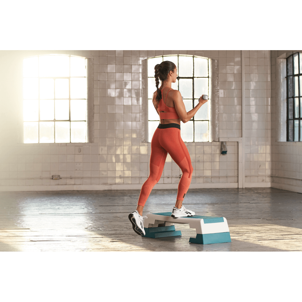 Woman performing a Reebok Step Workout - Teal