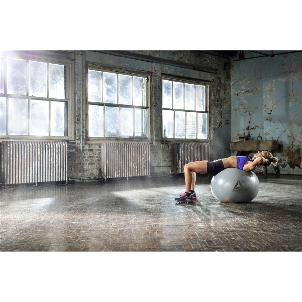 Woman exercising in the gym on a Reebok Womens Training Stability Gym Ball - 55cm