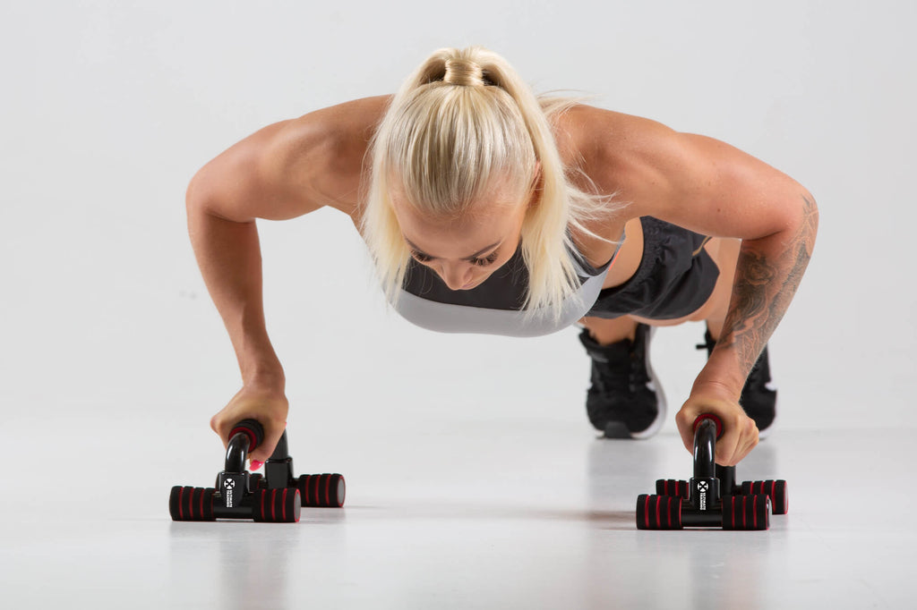 Woman performing push ups using UXT Angled Parallels - Push Up Bars