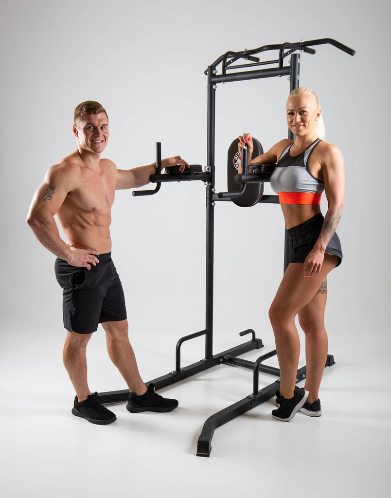 Man and woman standing next to a UXT Ultimate Power Tower